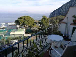ein Balkon mit Tisch und Meerblick in der Unterkunft La Marocella in Capri