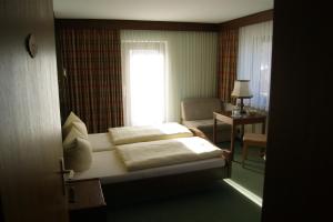 a hotel room with a bed and a window at Gästehaus Charlotte in Bayrischzell
