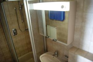a bathroom with a shower and a toilet and a sink at Gästehaus Charlotte in Bayrischzell