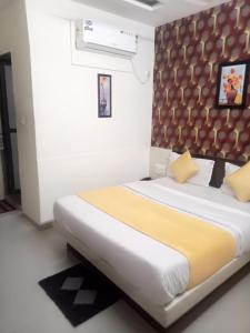 Hotel Gopi Palace في أحمد آباد: غرفة نوم بسرير كبير مع بطانية صفراء