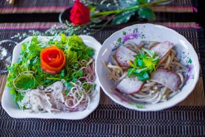 two plates of food sitting on a table at La Me Villa Hoi An in Hoi An