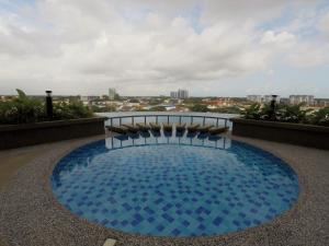 a large blue pool on the roof of a building at Zulanie Family Studio at D'Perdana Apartment, Spacious and Cozy with POOL, Free Wifi & Netflix in Kota Bharu