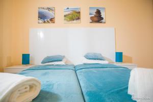 a bedroom with two beds with blue sheets at Baltic in Pogorzelica