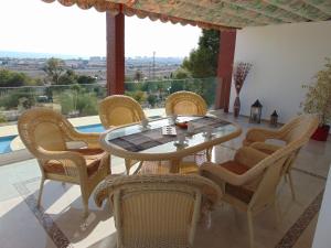 a patio with a table and chairs and a pool at Villa Altavista El Campello, Alicante in El Campello