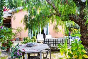 マッサ・ルブレンセにあるLa Casa del Pepe rosaの木の下の庭のテーブルと椅子