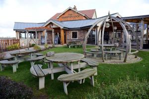 a picnic table and benches in front of a building at Gamston Lock, Nottingham by Marston's Inns in Nottingham
