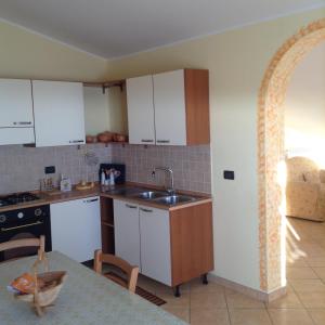 een keuken met witte kasten en een wastafel bij L' Alba di Alice in Silvi Marina