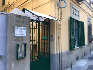ナポリにあるCasetta San Martinoの看板が付いた緑の扉のある建物