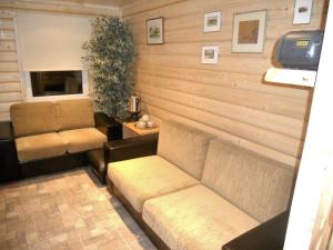 a living room with a couch and two chairs at Viesu māja Forrest in Dzimtmisa