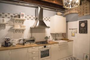 a kitchen with white cabinets and a stove top oven at Hospitale I Mori in Asola