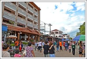 een menigte mensen die over straat lopen bij Riverfront Hotel Mukdahan in Mukdahan