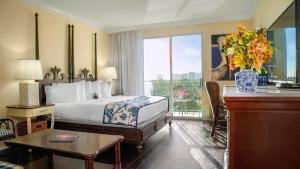 a hotel room with a bed and a large window at Inn at Pelican Bay in Naples