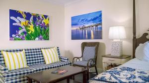 a hotel room with a bed and two chairs at Inn at Pelican Bay in Naples