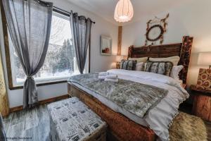 - une chambre avec un grand lit et une fenêtre dans l'établissement Le Vanilee - Les Chalets Spa Canada, à La Malbaie