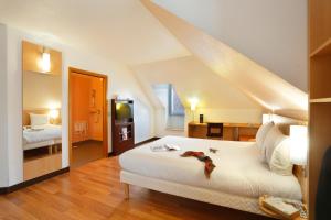 a bedroom with a large white bed and a staircase at ibis Etampes in Étampes