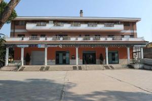 a large red building with steps in front of it at Hotel Casarola - Trigoria in Castel di Decima