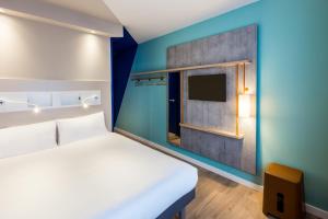a room with a bed and a tv at ibis budget Amsterdam City South in Amstelveen
