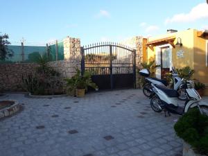 a scooter parked next to a building with a gate at Le casette di Simona in Lampedusa