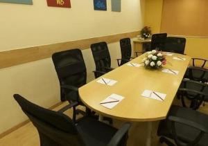 a conference room with a wooden table and chairs at Ginger Agartala in Agartala