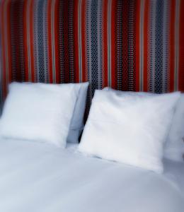 ein Bett mit zwei weißen Kissen in einem Zimmer in der Unterkunft Casa Vitória Guest House in Évora