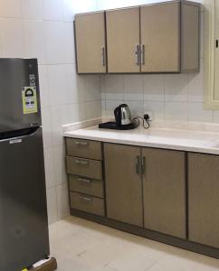 une cuisine avec un évier et un réfrigérateur dans l'établissement Taleen Riyadh Residential Units, à Riyad