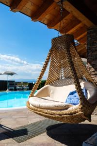 un columpio de mimbre colgando de un techo junto a una piscina en Sweet Life Villas, en Peschiera del Garda
