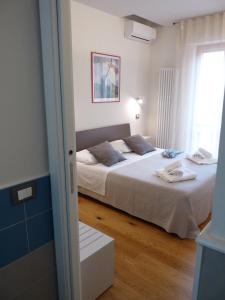 a bedroom with a large white bed and a window at Ánemos b&b in Termoli