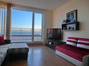 a living room with a couch and a flat screen tv at 2 bedroom Imperial apartment with panoramic sea views, Sveti Vlas in Sveti Vlas