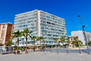 カルプにある3- bedroom apartment in the centre of Calpe with nice living room, 1 bathroom.のヤシの木が目の前にそびえる白い高い建物