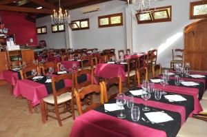 Un comedor con mesas y sillas con manteles rosas. en Camping La Estanca, en Alcañiz