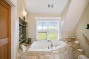 a white tub in a bathroom with a window at Black Rock Beach House in Ucluelet +60 photos
