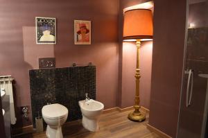 La salle de bains est pourvue de toilettes et d'une lampe. dans l'établissement Viola Home, à Turin