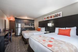 a hotel room with two beds and a kitchen at Hawthorn Suites Las Vegas in Las Vegas