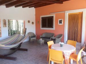 d'une terrasse avec une table, des chaises et un hamac. dans l'établissement Casa di Lory a Bruca, à Scicli