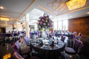 una sala banchetti con un lungo tavolo e sedie viola di The Saddleworth Hotel a Diggle