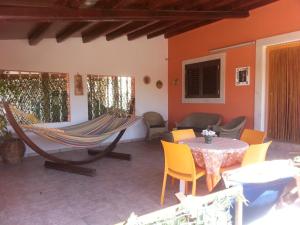 d'une terrasse avec un hamac, une table et des chaises. dans l'établissement Casa di Lory a Bruca, à Scicli