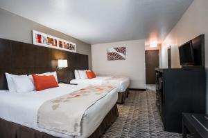 um quarto de hotel com duas camas e uma televisão de ecrã plano em Hawthorn Suites Las Vegas em Las Vegas