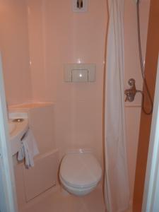 een kleine badkamer met een toilet en een wastafel bij Relax Hotel in Maillat