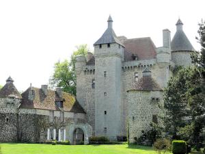 a large castle sitting on top of a lush green field at Appartement d'Hôtes in Guéret