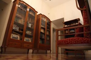 a living room with a wooden cabinet and a chair at B&B Casa Ruffino in Balestrate