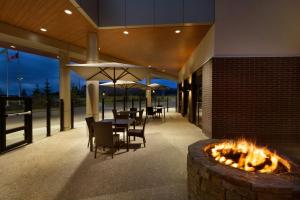 a patio with tables and chairs and a fire pit at Hotel Dene & Conference Centre in Cold Lake