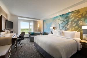 a hotel room with a bed and a desk at Hotel Dene & Conference Centre in Cold Lake +19 photos