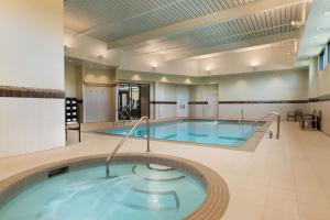 uma grande piscina com banheira de hidromassagem em Hotel Dene & Conference Centre em Cold Lake