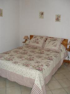 Un dormitorio con una cama con una manta. en appartement vacances à la montagne RDC en Génos