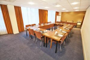 ハーレムにあるアムラス グランド ホテル フランス ハルスの大きな会議室(長いテーブルと椅子付)