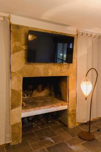 a stone fireplace with a television on top of it at ALEHUE Casa de Montaña in Villa La Angostura