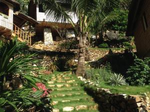 a garden with a palm tree and a stone path at Tinaoog Beach Resort in Romblon