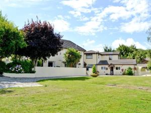 een groot wit huis met een grasveld bij Appletree Bungalow in Torquay