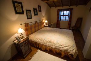 1 dormitorio con 1 cama, 2 lámparas y ventana en Casa do Passal en Bragança