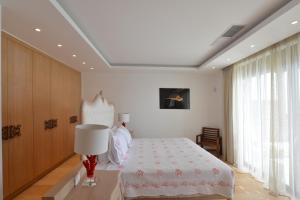 a bedroom with a bed and a table with a lamp at Villa Danae by Elounda Island View Villas in Elounda